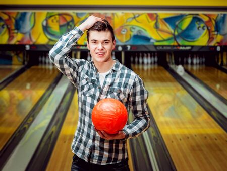 Young man at the bowling alley with the ball.の写真素材