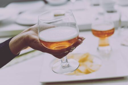 Glass of lager beer in the hands. Restaurantの写真素材