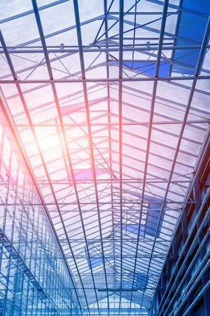 The frame of a modern greenhouse against the sky. Beautiful backgroundの写真素材
