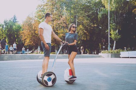 Young couple driving on monowheel in the parkの写真素材