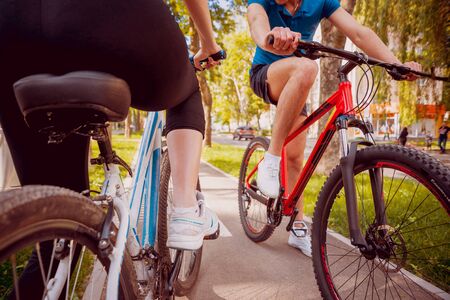 Cycling young couple. In the park. Beautiful bicycle laneの写真素材