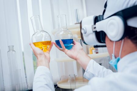 Science technician in virtual reality glasses examines the drug in laboratory. Medical backgroundの写真素材