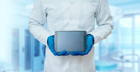Doctor holding blank screen tablet computer. At the pharmacyの写真素材