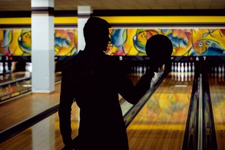 Young man at the bowling alley with the ballの写真素材