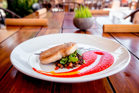 Fish with vegetables on a white plate. Restaurant.の写真素材