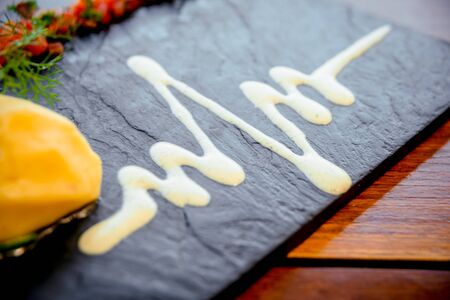 Fish with vegetables on a black plate.の写真素材