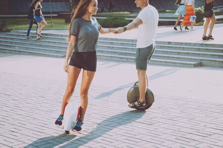 Young couple driving on monowheel in the parkの写真素材