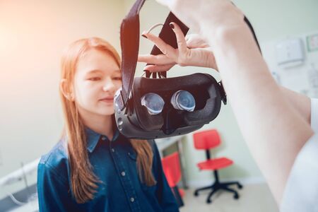 Ophthalmology doctor checks the girls vision with virtual reality goggles.の写真素材