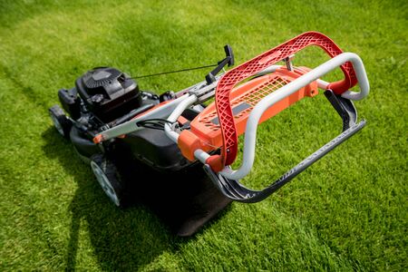 Lawn mower on green grass. Summer garden backgroundの写真素材
