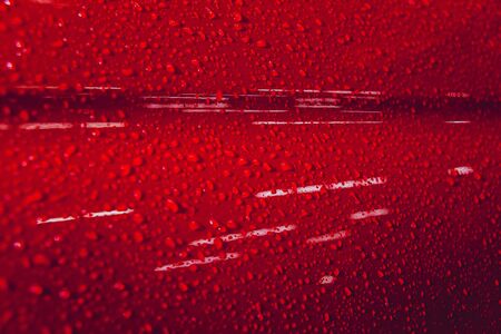 Water drops on red background. Car detailsの写真素材