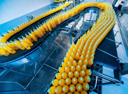 Beverage factory interior. Conveyor with bottles for juice or water. Equipmentsの写真素材