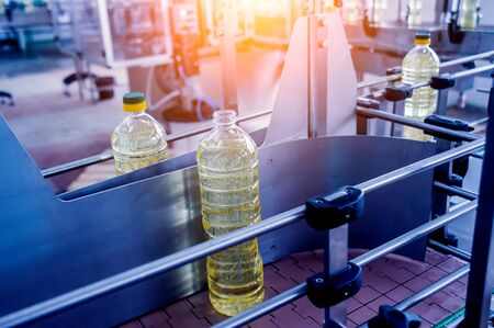 Bottling line of sunflower oil in bottles. Vegetable oil production plant.の写真素材