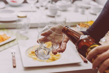 Glass of lager beer in the handsの写真素材