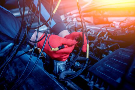 Auto mechanic uses a voltmeter to check the voltage level. Car repair. Service station.の写真素材