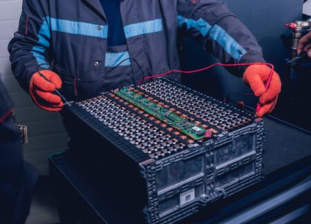 Charging the batteries of the elecric motor. Disassembling the battery of an electric vehicle engine. Car serviceの写真素材