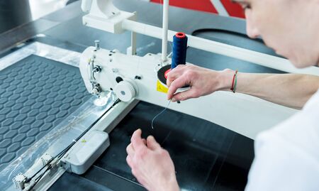 Fabric industry production line. Textile factory. Working tailoring process cloth. Modern equipmentの写真素材