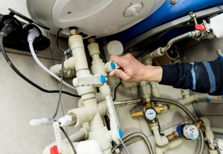 Heating engineer fixing modern heating system in boiler room. Automatic control unit. Engineering...