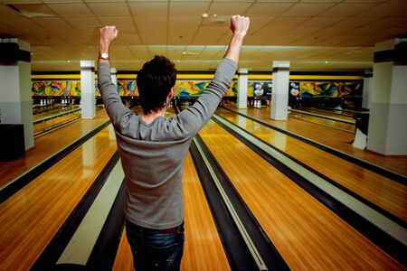 Young man at the bowling alley with the ballの写真素材