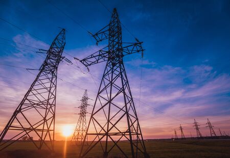 High-voltage power lines at sunset. Electricity distribution station. Backgroundの写真素材
