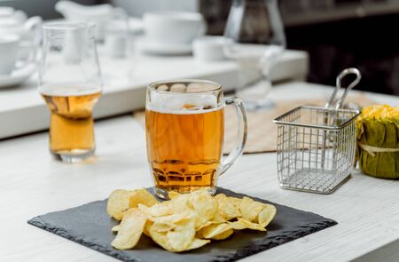 Beer and chips on the large white table. Restaurantの写真素材