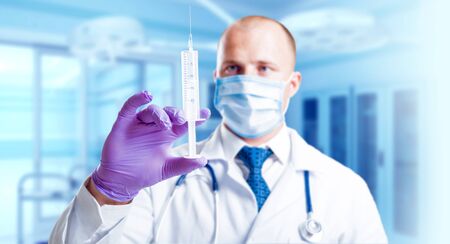 Experienced doctor in operating room. Light background.の写真素材
