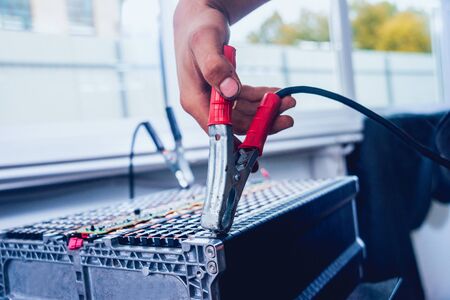 Charging the batteries of the elecric motor. Disassembling the battery of an electric vehicle engine. Car serviceの写真素材
