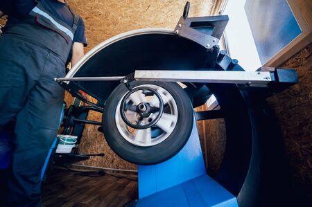 Professional car mechanic replace tire on wheel. Auto repair service. Car wheel balancingの写真素材