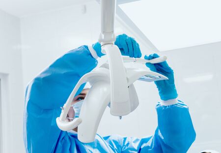 Preparation for dental surgery, fixing sterile handles to the luminaireの写真素材