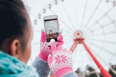 Beautiful girl taking picture of a Ferris wheelの写真素材