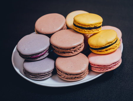 Colorful macaroons. Sweet macarons on retro dark background