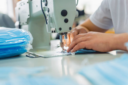 Woman sew the facial medical at sewing machine. Coronavirus pandemia.の写真素材