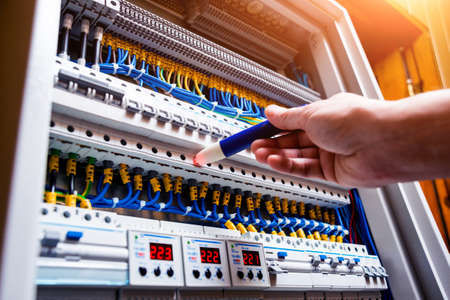 Checking voltage in switchboard with a detector. Electrical backgroundの写真素材