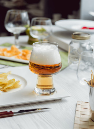 Beer and chips on the large white table. Restaurant