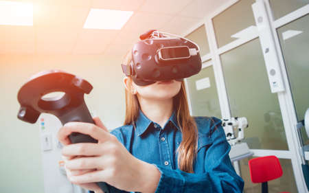 Eye treatment. Patient in virtual reality goggles. Checking the girl's vision with the help of virtual reality. Ortoptics. Pleopticsの写真素材