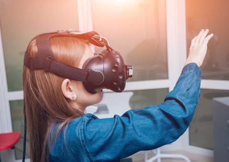 Ophthalmology doctor checks the girl's vision with the help of virtual reality goggles. Virtual...