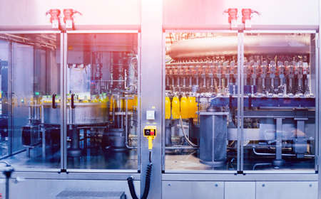 Automatic filling machine pours water into plastic PET bottles. Brewing production. Industrial background.の写真素材