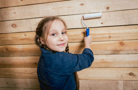 Little girl in a room with a wooden wall. Constructionの写真素材