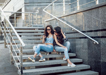 Young girls with skateboard sitting on the stairsの写真素材