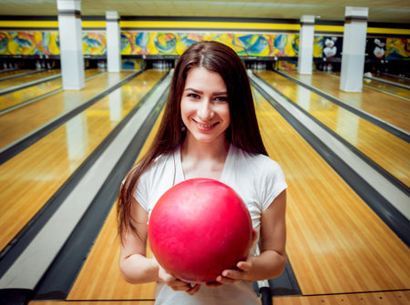 Beautiful girl at the bowling alley with the ball.の写真素材