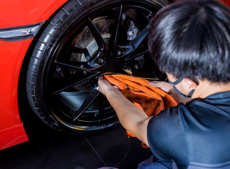 Car service worker polishing car wheels with microfiber cloth. Tools for polishingの写真素材