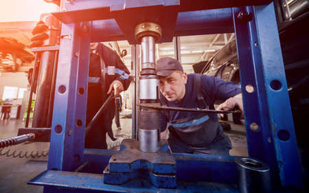 Car mechanic press new silentblock at repair service station. Auto service.の写真素材