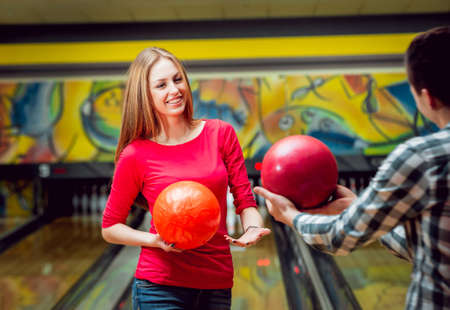 Cheerful friends at the bowling alley with the balls.の写真素材
