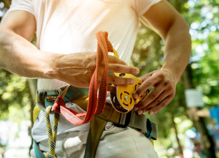 Young man in adventure rope park. Climbing Equipment.