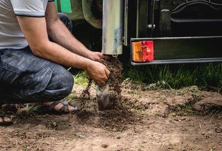 Soil examination. Collecting black soil on the field for examinationの写真素材