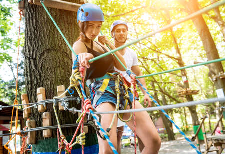 Young couple having fun time in adventure rope park.の写真素材