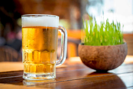 Mug of cold beer with foam on the table.の写真素材