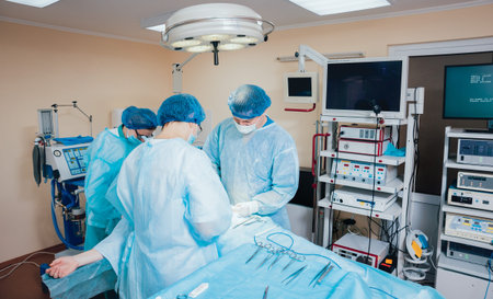 Group of surgeons in operating room with surgery equipment.