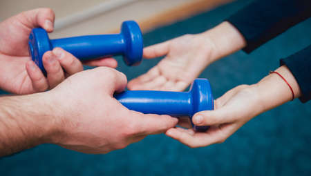 Hands with dumbbells. Sport equipment practice. Backgroundの写真素材