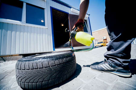 Professional car mechanic replace tire on wheel.の写真素材