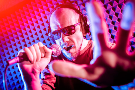The singer sings with a microphone in the recording studio.